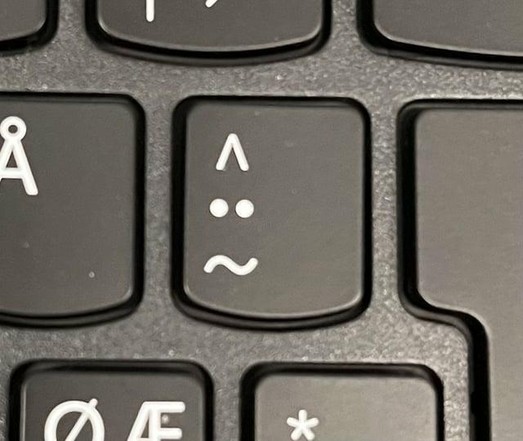 A key with a pointy hat, two dots like eyes, and a mouth from a tilde character

Together it looks ... perplexed and worried