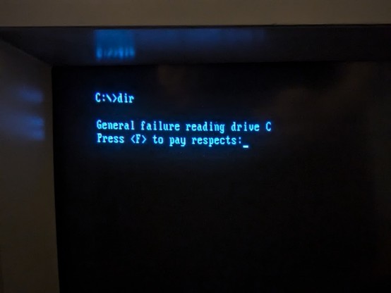 Photo of a CRT monitor with the following DOS message

C:\>dir 

General failure reading drive C
Press <F> to pay respects: