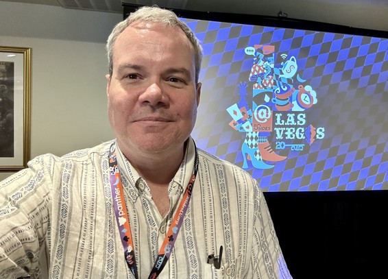 Me with a projection screen showing the BSides Las Vegas logo behind me. 