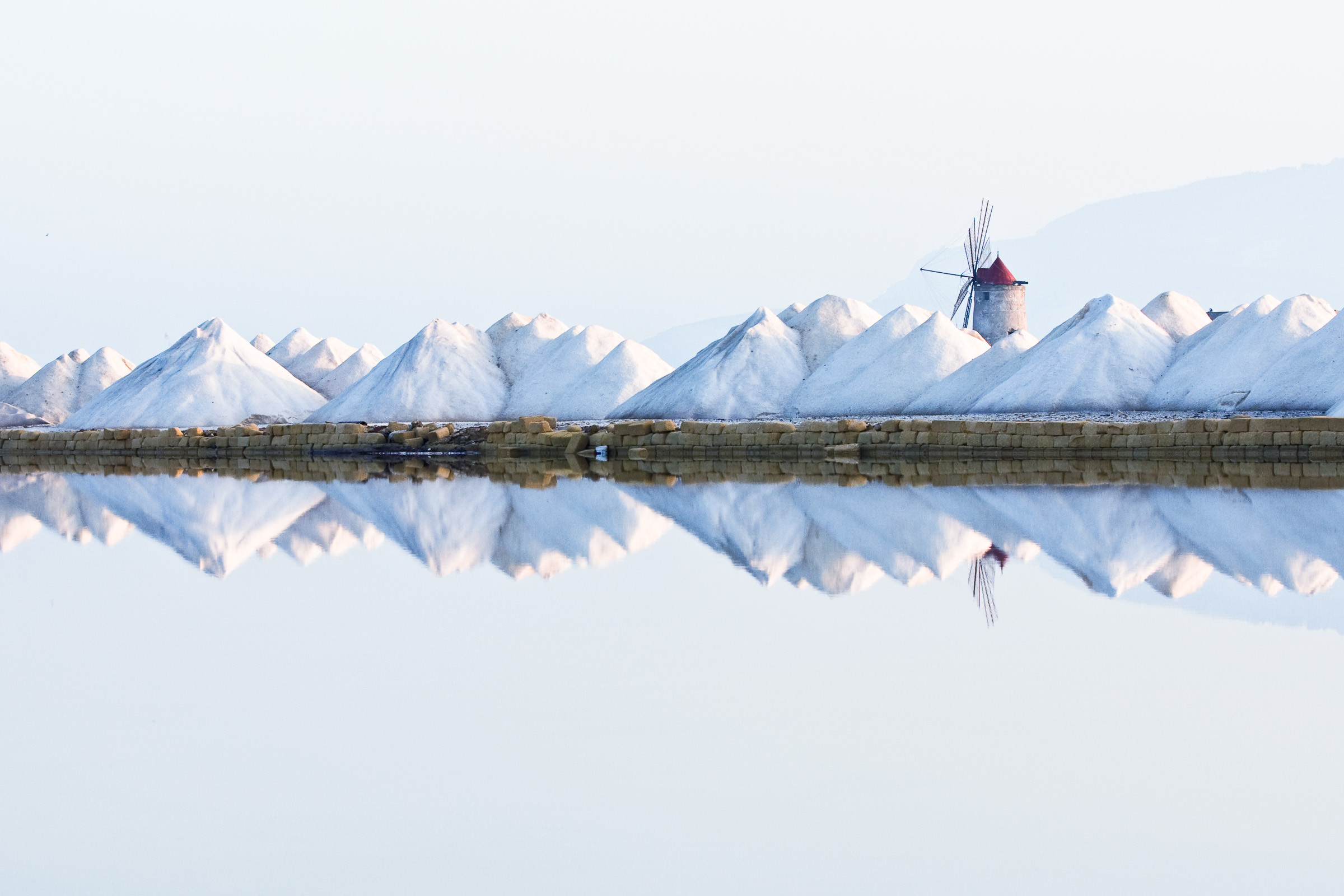 kleine, aufgeschüttete Kegel aus Salz, die sich im Wasser der Saline spiegeln. kleine, aufgeschüttete Kegel aus Salz, die sich im Wasser der Saline spiegeln.