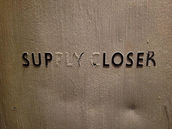 Photo of a door that originally said, "SUPPLY CLOSET", but now has been crudely modified to say, "SUP LOSER".