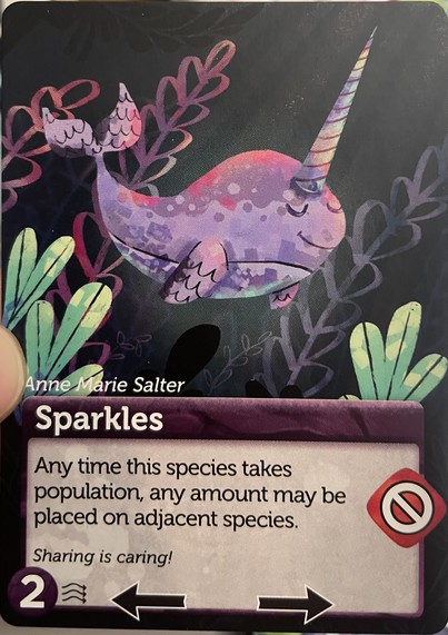Card for Oceans game with a picture of a purple and pink whale and a unicorn's horn. Flavor text "Sharing is caring!"