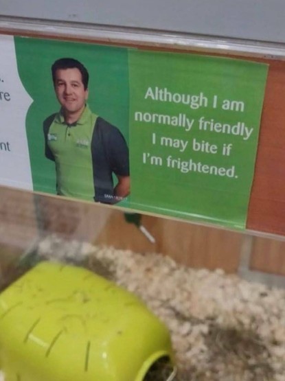 Photo of a pet store associate above a hamster cage with a notice that says, "Although I am normally friendly, I may bite if I'm frightened."