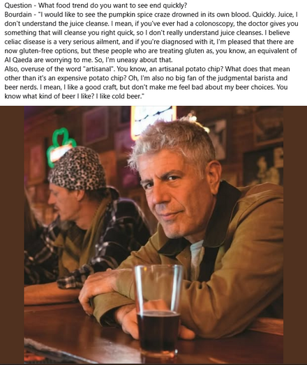 The image features a medium shot of Anthony Bourdain seated at a bar, with a glass of dark beer in front of him. He is the primary focus, with his face and upper body well-lit. He is looking towards the camera with a slight, knowing smile, suggesting a sense of amusement or contemplation. He is wearing a tan jacket over a light-colored shirt, and his graying hair is styled in a slightly disheveled manner. His skin has a warm, natural tone, and his expression is relaxed.

To the left and slightl…