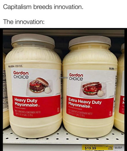 The image is a close-up photograph of two large plastic containers of mayonnaise displayed in a supermarket setting. The containers are cylindrical, with a slightly off-white, creamy color. They have wide, flat lids of a similar color, and a label wraps around a portion of the container's body.

The left container is labeled "Heavy Duty Mayonnaise," with a red rectangular label containing white text. Above the text is a picture of a burger. The right container is labeled "Extra Heavy Duty Mayon…