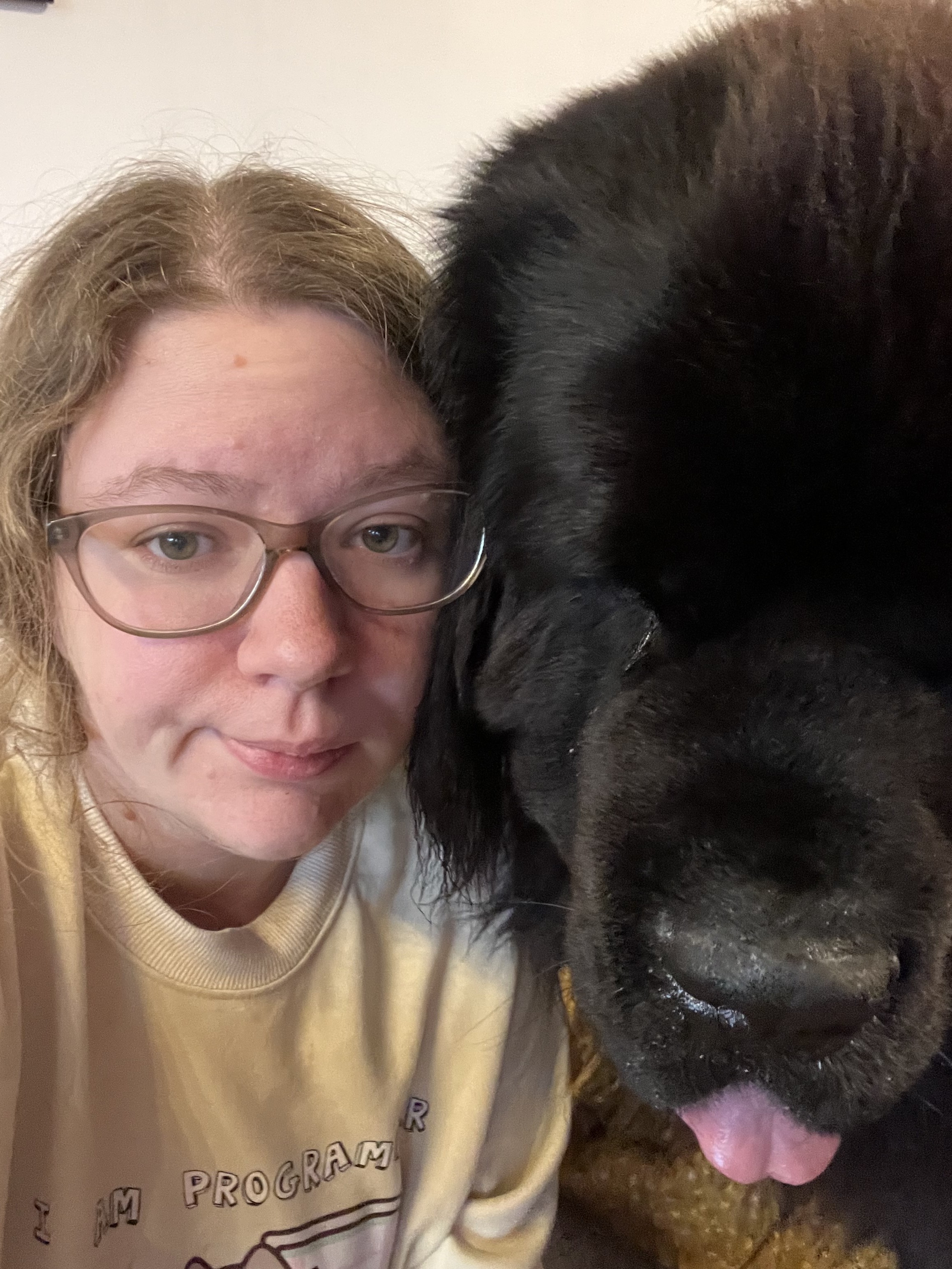 Selfie of me, extremely sleep deprived, and Odin the Newfie doing a blep