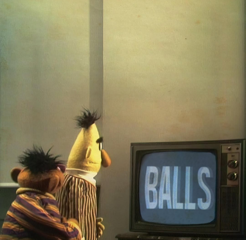 Bert and Ernie looking at a CRT television displaying the word BALLS