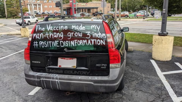Back of a car with Ohio plates - with the following text scrawled on teh back windshield: 
The Vaccine mad my man-thnag grow 3 inches #PositiveDisInformation