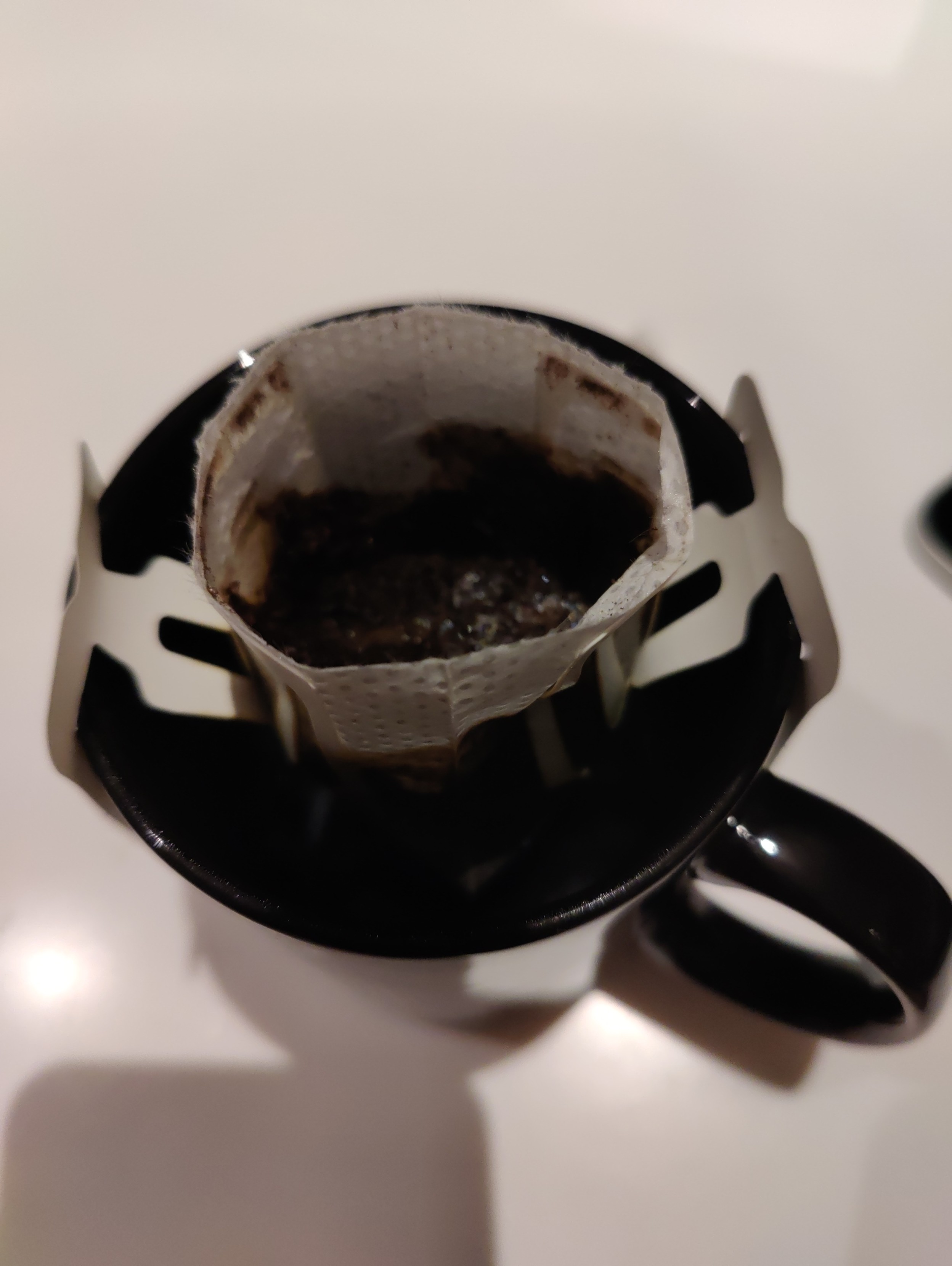 The filter bag in use.  Water is going through the coffee grounds and dripping into the mug.