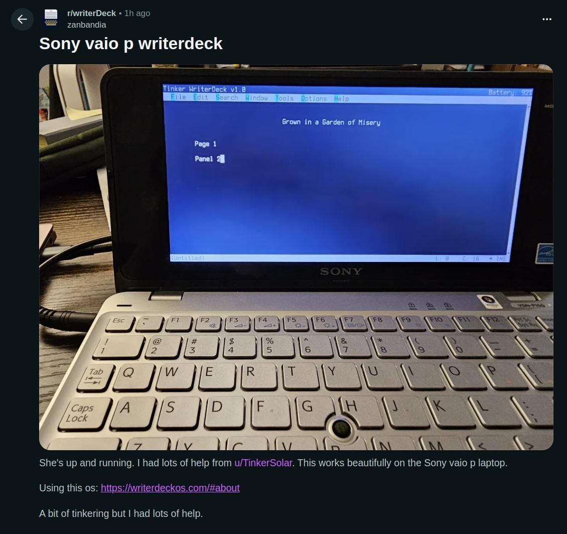 writerdeckOS running on a 32bit Sony Vaio P netbook. The screen shows the tilde text editing program with the text "Grown in a Garden of Misery. Page 1. Panel 2" written on the screen as a demo.