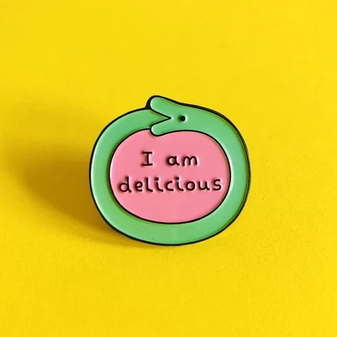 Ouroboros pin that says, "I am delicious"