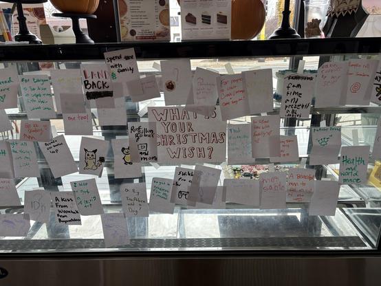 lots of christmas wish notes on a bakery case