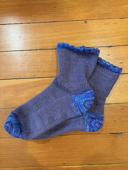 two homemade purple socks with blue/purple accents