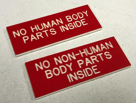 Photo of two red signs which say

NO HUMAN BODY
PARTS INSIDE

and

NO NON-HUMAN
BODY PARTS
INSIDE