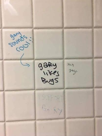 Bathroom graffiti that has "Gary likes bugs" on one tile with three neighboring and tiles written by different people that say "Gary sounds cool!!", "Yeah Gary", and "I support Gary"