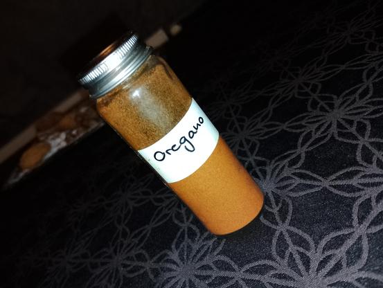 Offensichtlich mit Cayenne, chili oder paprika gefüllter Gewürzstreuer, Aufschrift "Oregano".