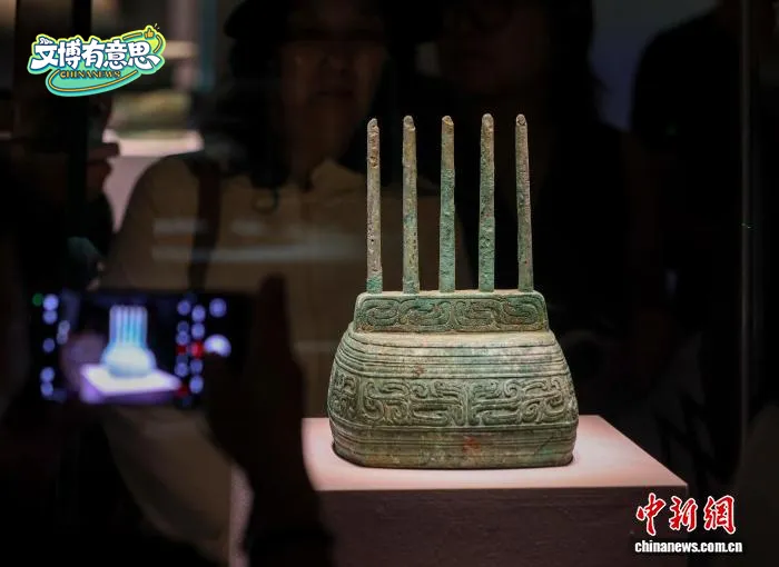 a small, ancient bronze object consisting of a rectangular base with five candle-like pillars, with a striking resemblance to a multi-antenna wifi router. 