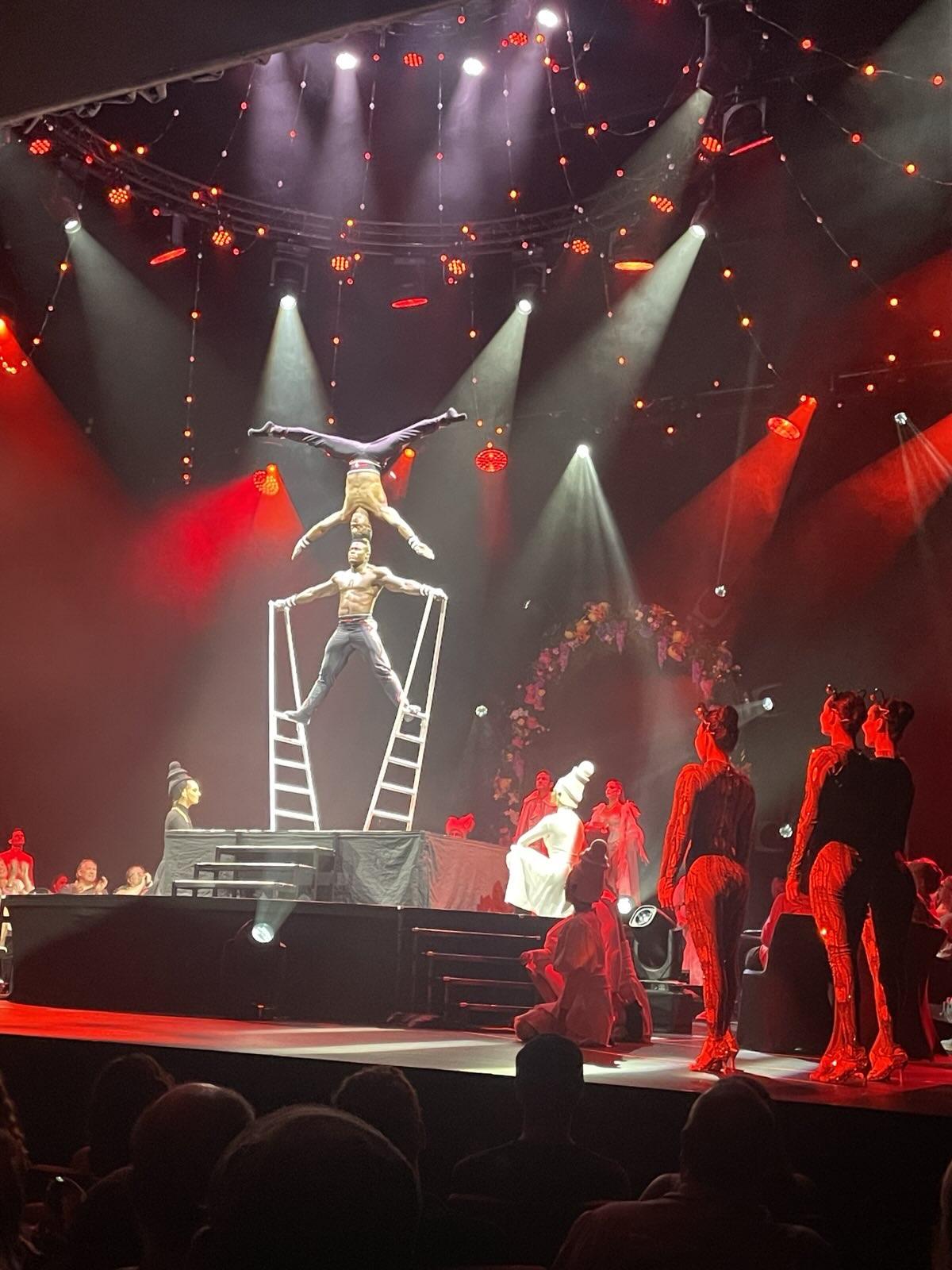 A robot standing on two ladders, another inverted on his head