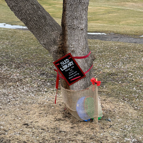 Sign that says Sled library with sleds beneath it