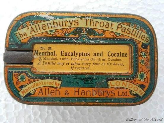 The image displays a close-up, slightly angled view of an old, rectangular metal tin, likely for throat pastilles. The tin has a distressed, aged appearance with visible scratches and wear, particularly along the edges and surfaces, revealing hints of a lighter metal underneath. The background is a textured white surface.

The tin features an ornate design with a dominant color palette of orange, teal, and yellow. The outer border is a teal band decorated with a repeating pattern of small, styl…