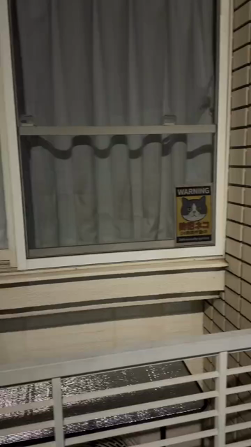 Video of someone looking at a window with the sign showing a cat head and:

WARNING
防犯ネコ
24時間作勤中
24H security system

The video then pans to the left where there's an identical looking cat sitting by the window, staring directly at the human filming. The cat moves it's head slightly up as if signaling to the person that it knows... It knows...