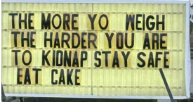 Sign that says "the more you weigh, the harder you are to kidnap. Stay safe, eat cake.