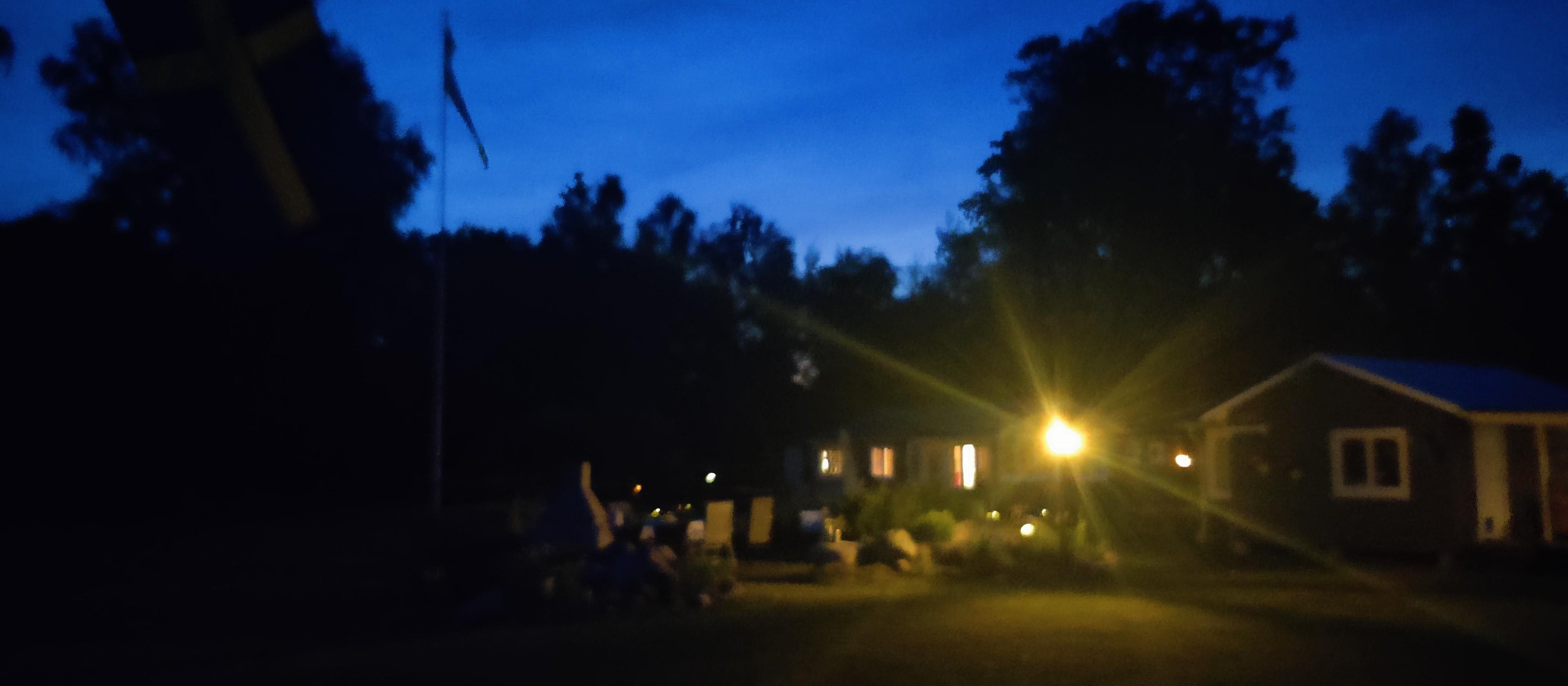 Photo taken last nigh over the yard outside of our cabin, dark out, lamp shining, sky magically shiny in the Swedish summer way😉