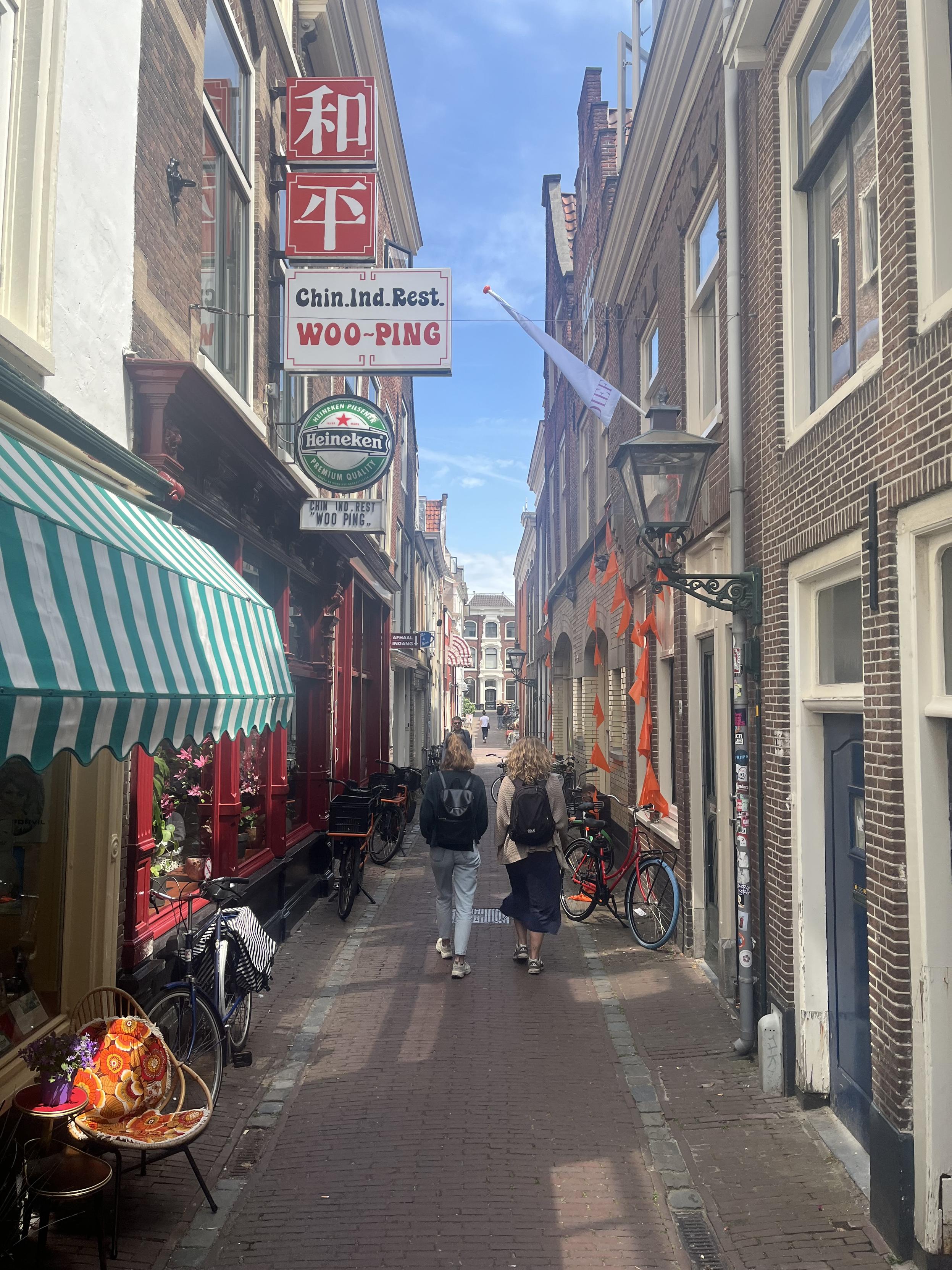 Cozy narrow market alleyway with Dutch sports flags and Chinese-Indonesian restaurant