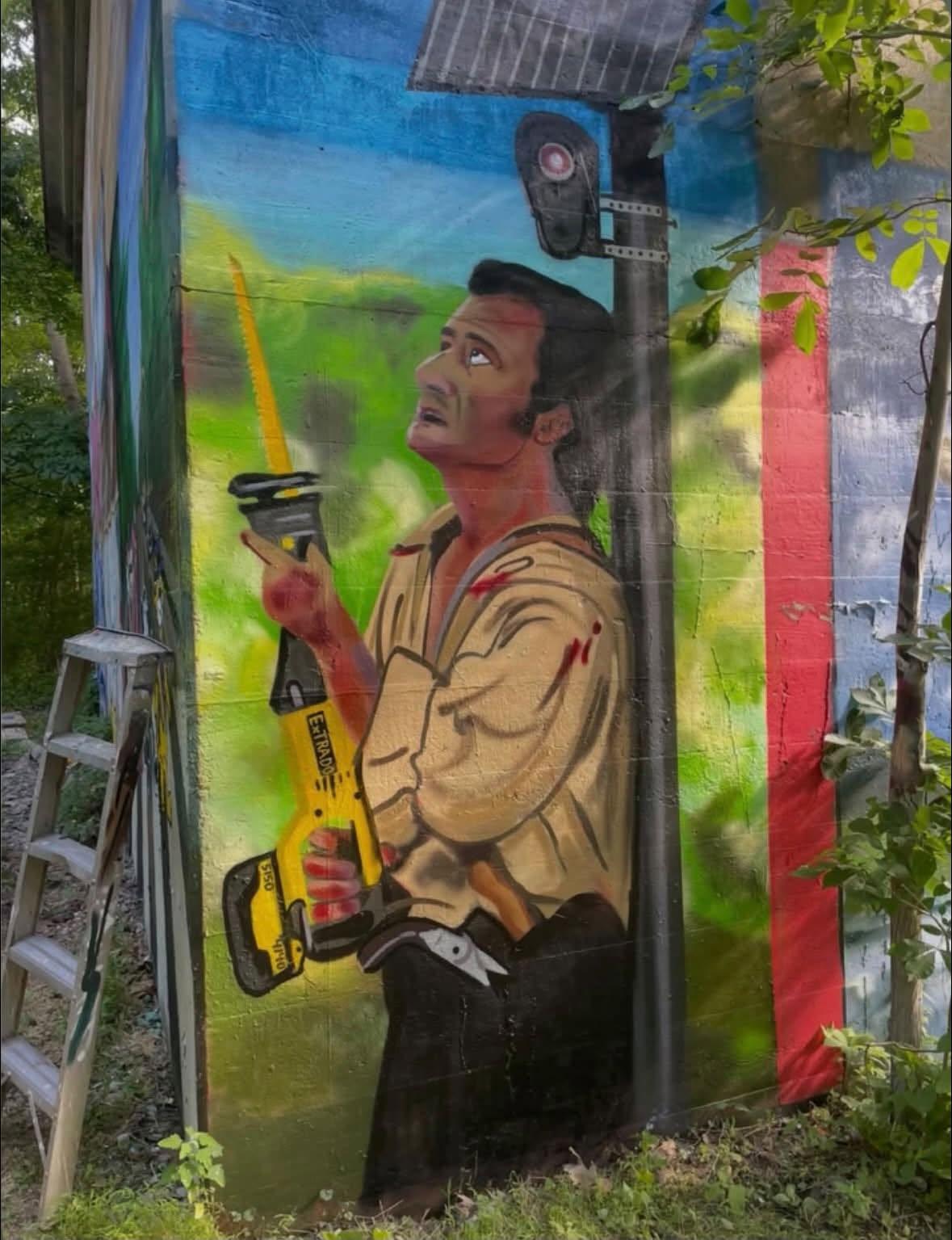 A mural of Mel Gibson from "The Patriot", except he's holding a sawzal to a floc camera :)