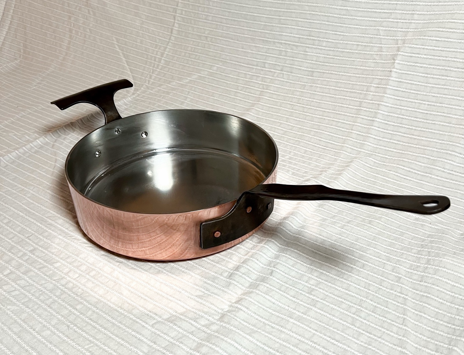 A tin-lined copper roasting pan with a forge hammered stainless steel handle and helped handle from Rocky Hill Forge. Https://rockyhillforge.com