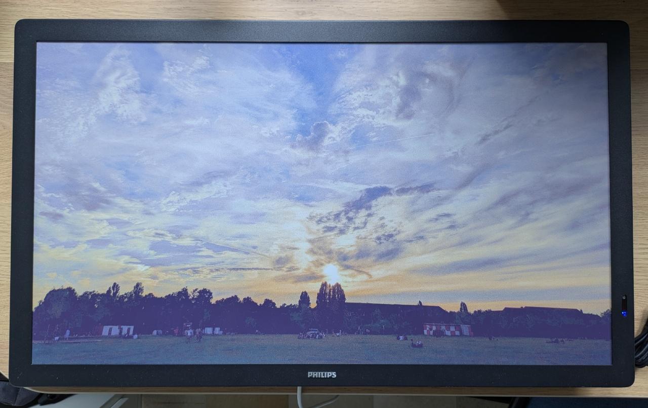 A colour e-ink display showing a sunset and a cloudy sky.