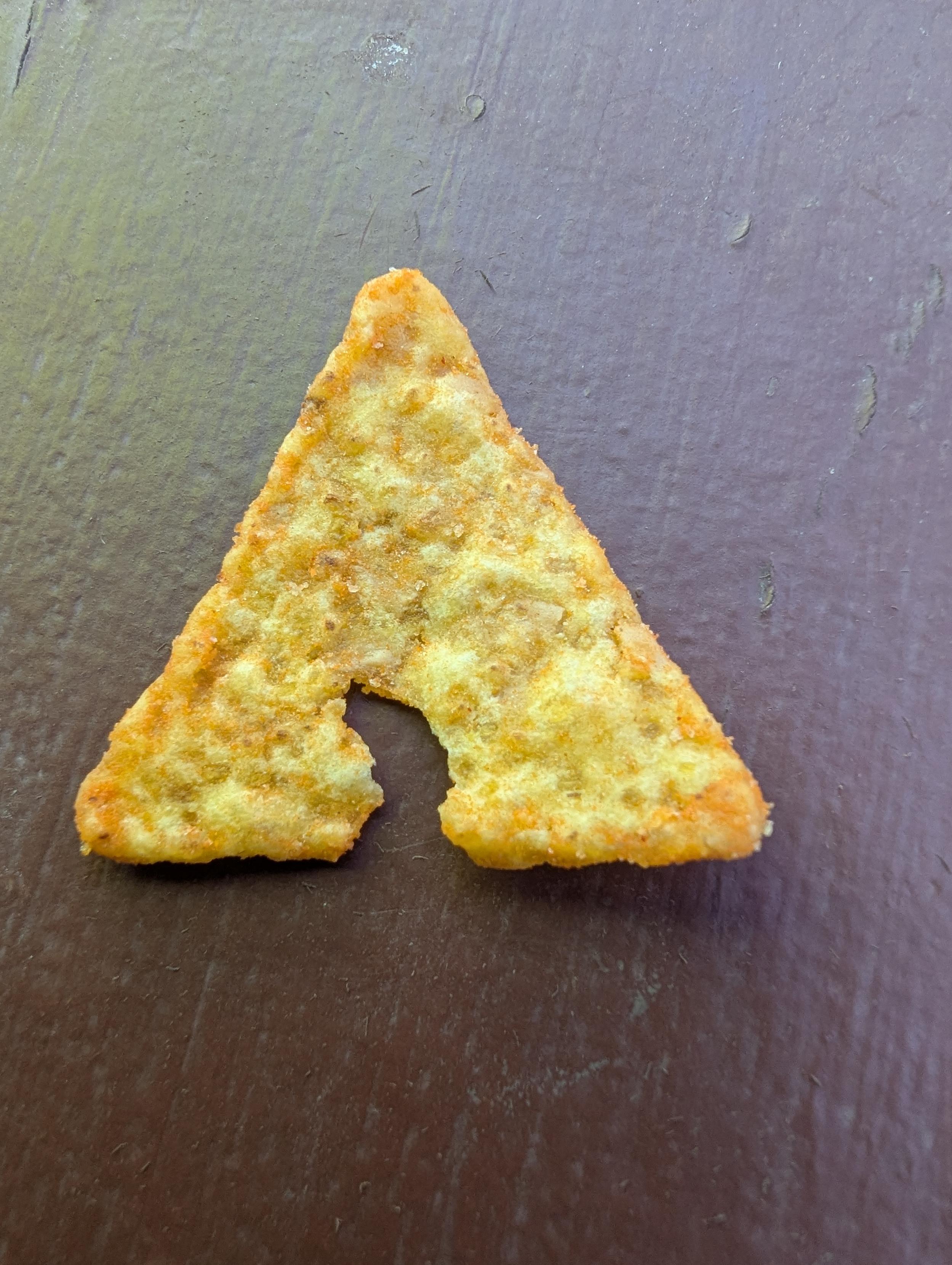 triangle shaped taco chip with small chunk missing from bottom section of chip sort of like the Arch Linux logo.