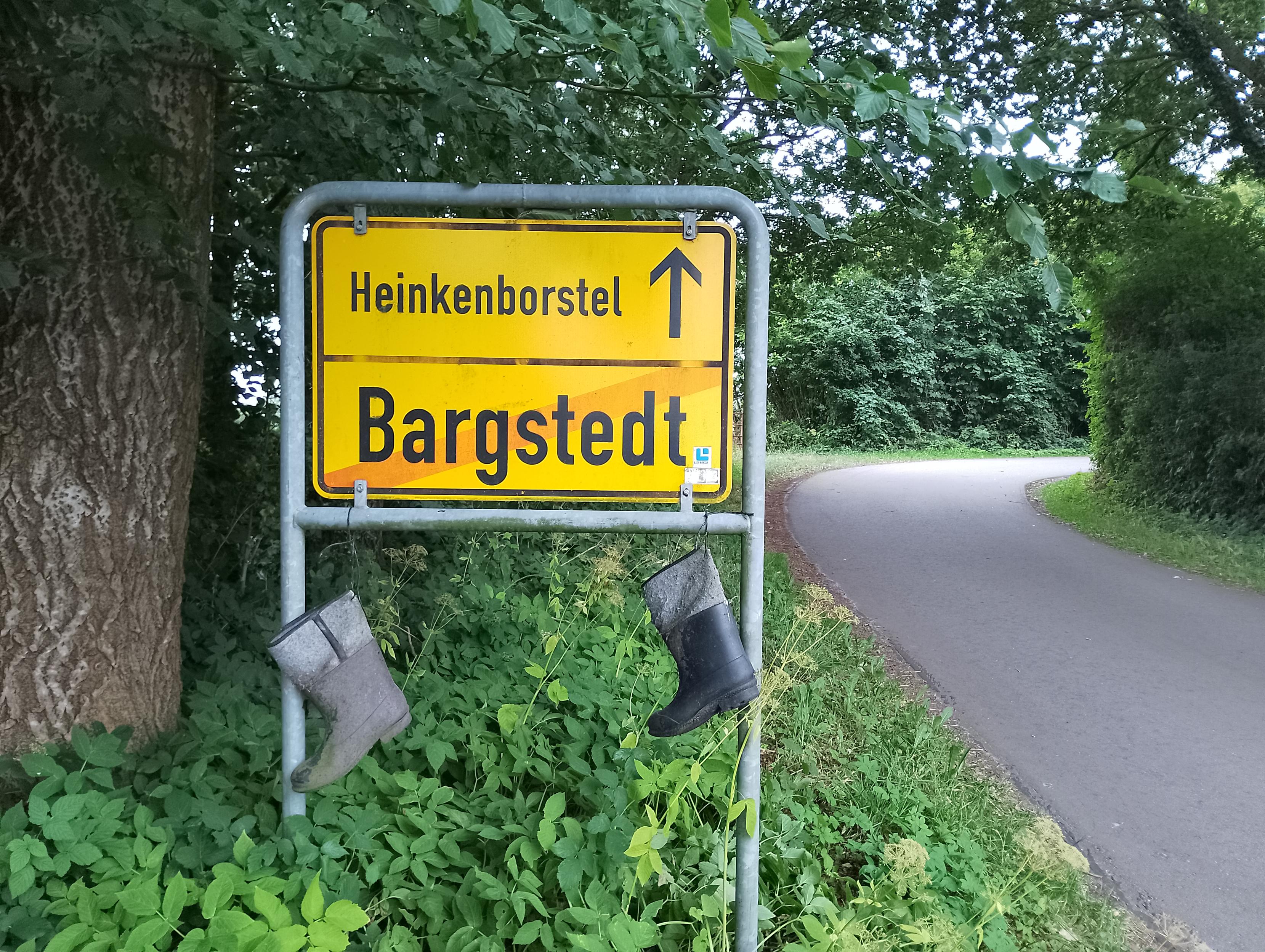 Ortsschild mit Gummistiefeln dran