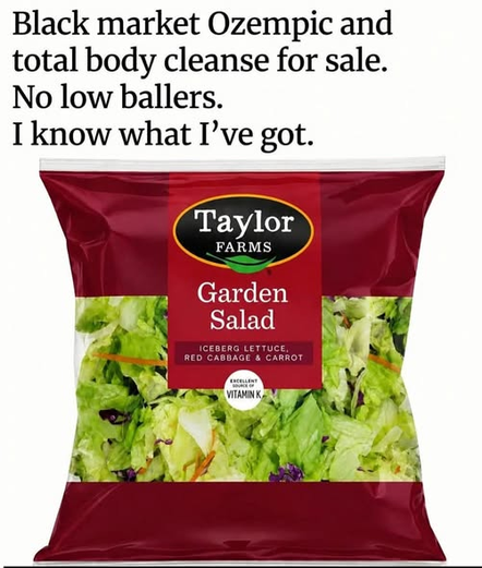 The image displays a bag of Taylor Farms Garden Salad. The bag has a deep red color and is transparent at the front, revealing the salad mixture inside. The salad consists of shredded iceberg lettuce, thinly sliced carrots, and bits of red cabbage. The Taylor Farms logo, a red oval with "Taylor Farms" written in white text and a green leaf design, is prominently featured on the upper part of the red packaging. Below the logo, "Garden Salad" is written in large white text. Smaller text beneath i…