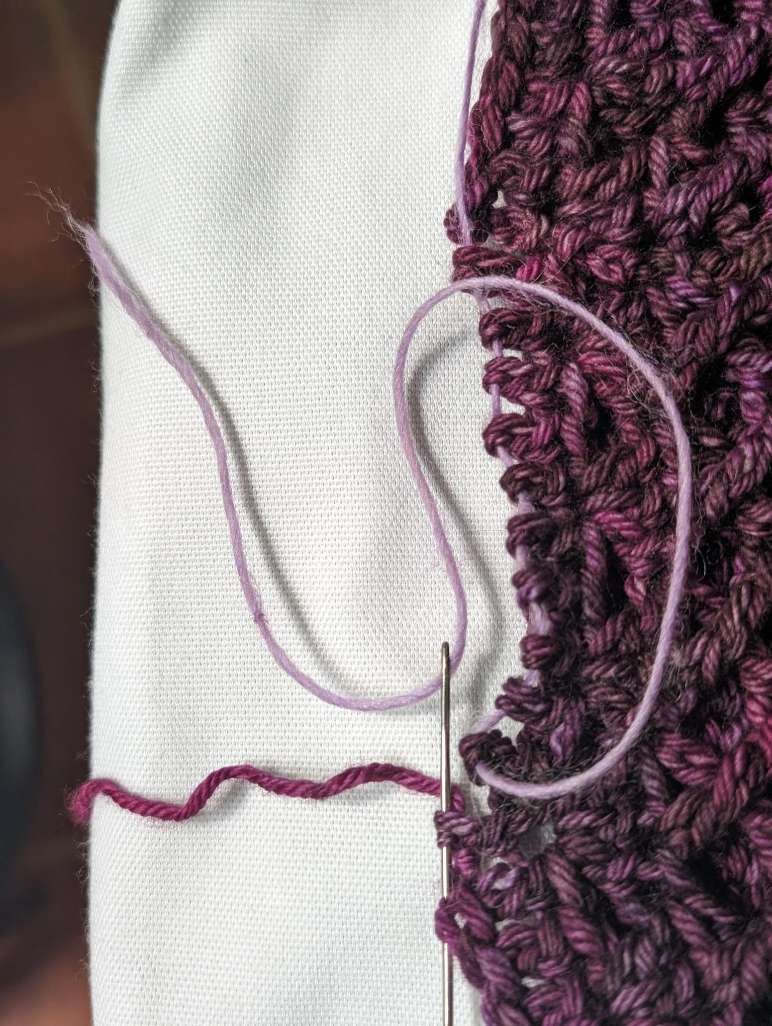 using an upholstery needle to thread a line through the base of all the double-crochets as I rip out the foundation chain