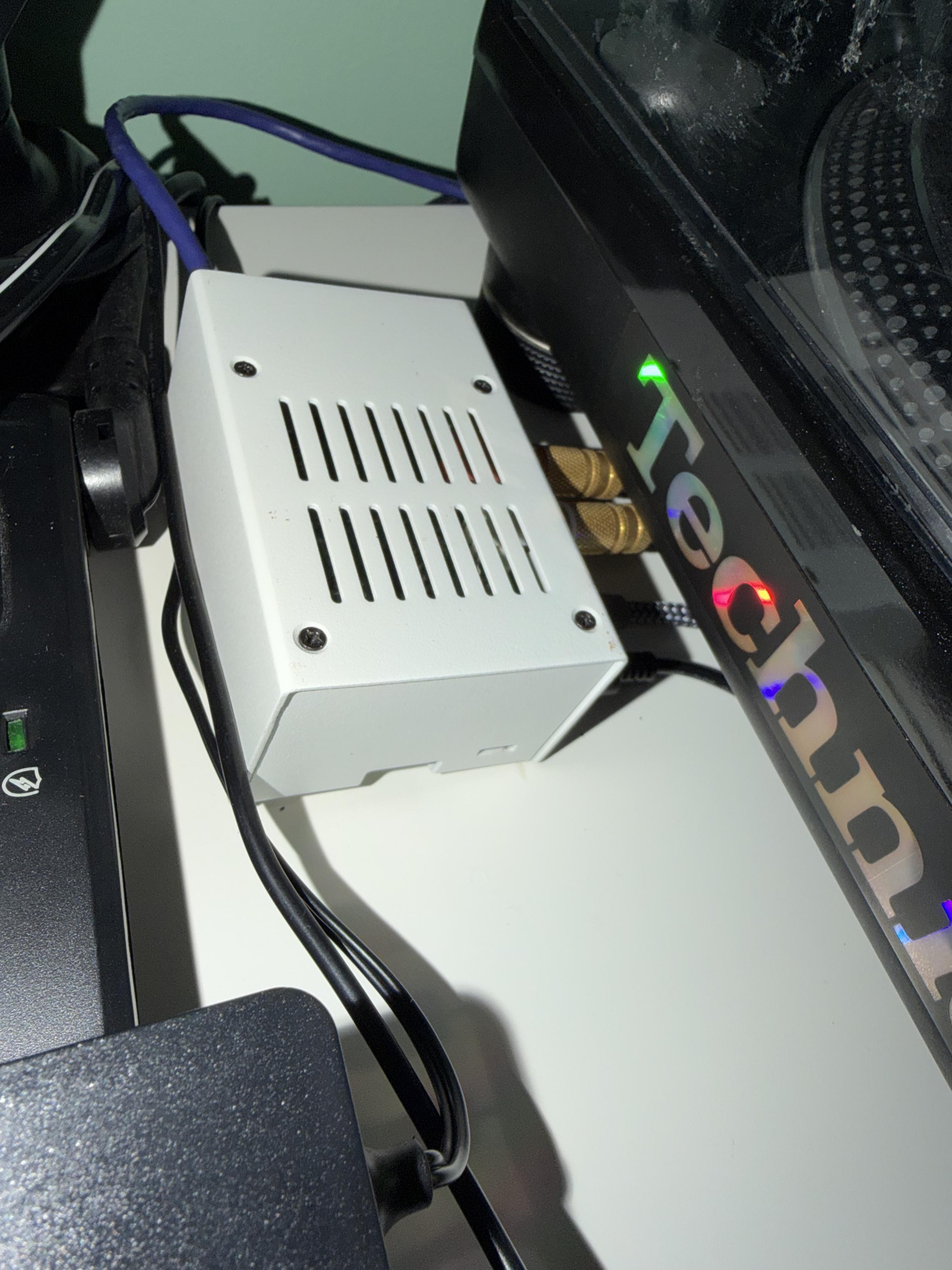 Raspberry pi with a DAC in a steel case next to a turntable.