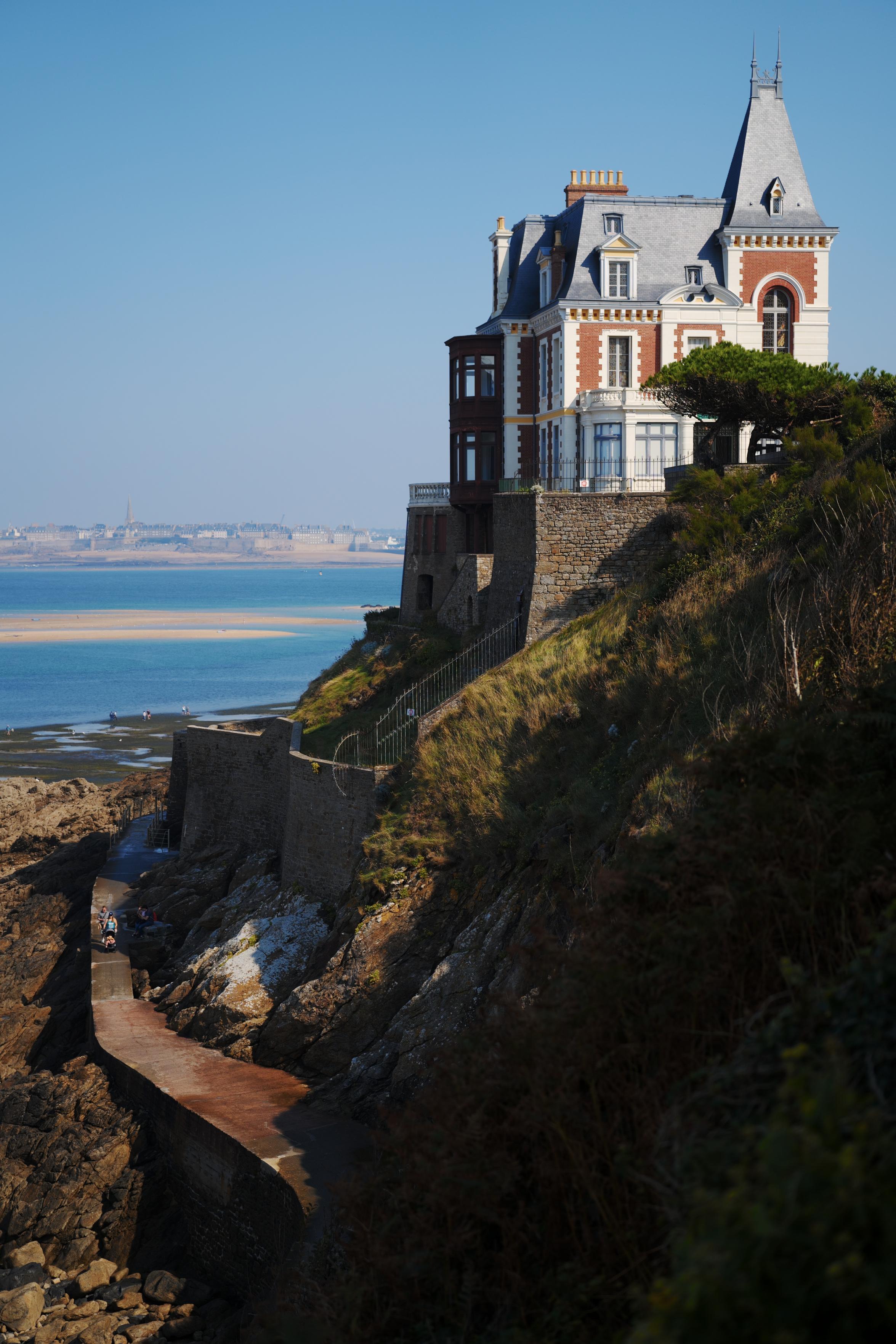 A fancy old house on a cliff by the sea.