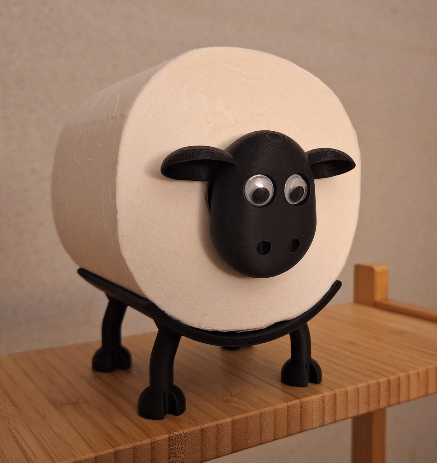 Ein Schaf, dessen Rumpf aus einer Klopapierrolle besteht.
Kopf und Beine sind aus schwarzem Kunststoff, 3D-gedruckt.
Es hat Kulleraugen.