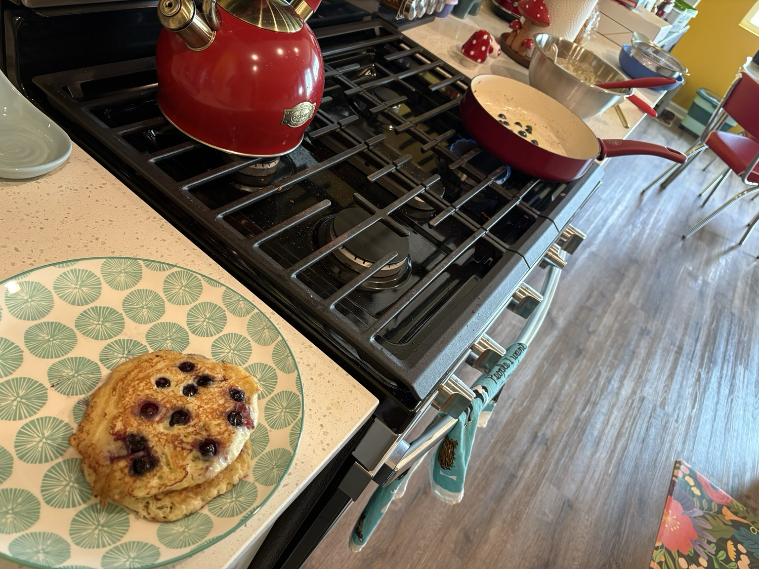 Picture of kitchen with batter, skillet, and pancakes in progress and complete