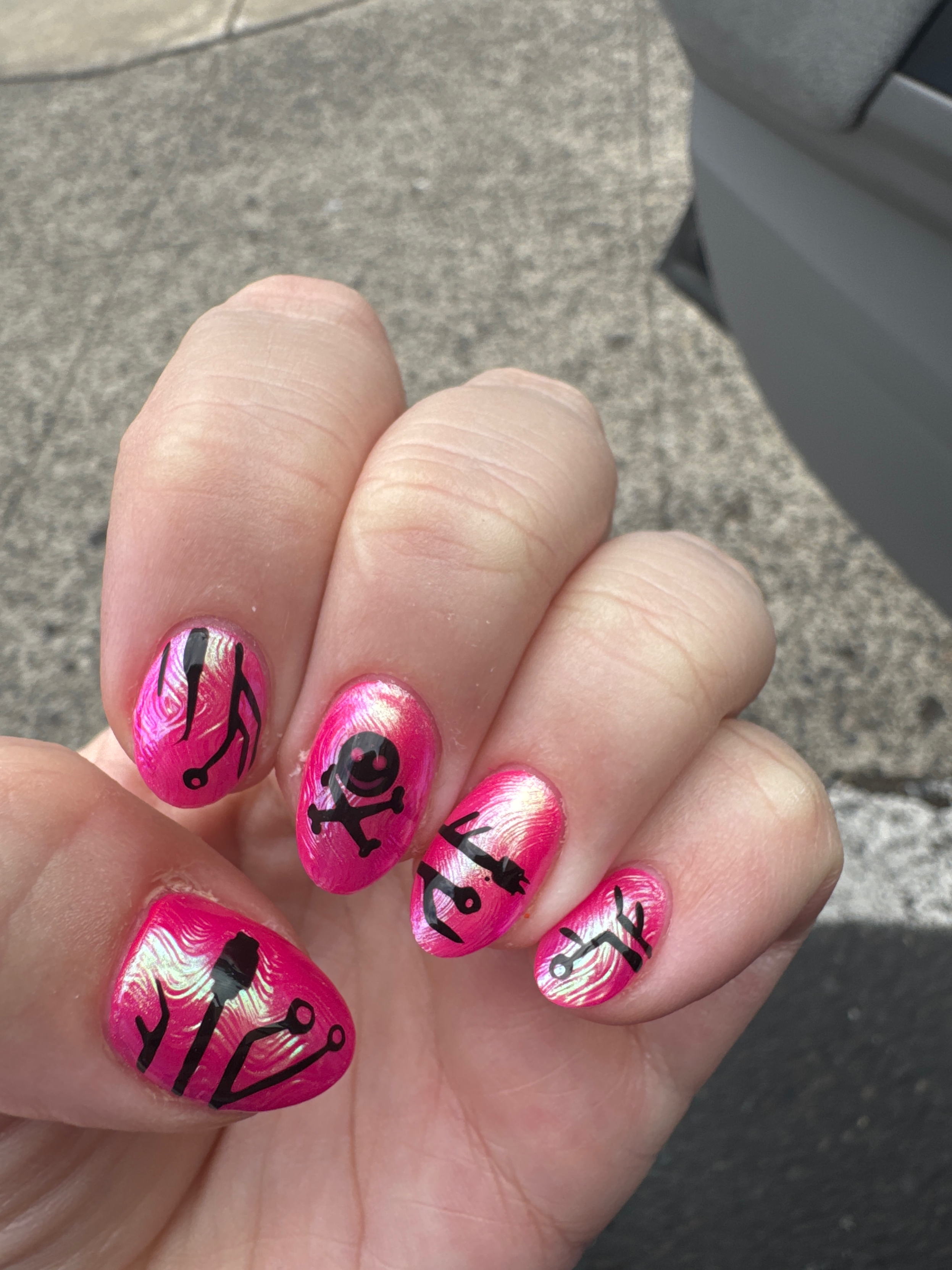 Hot pink nails with a chrome sheen added with nail art featuring lock picks, a power cable, and usb