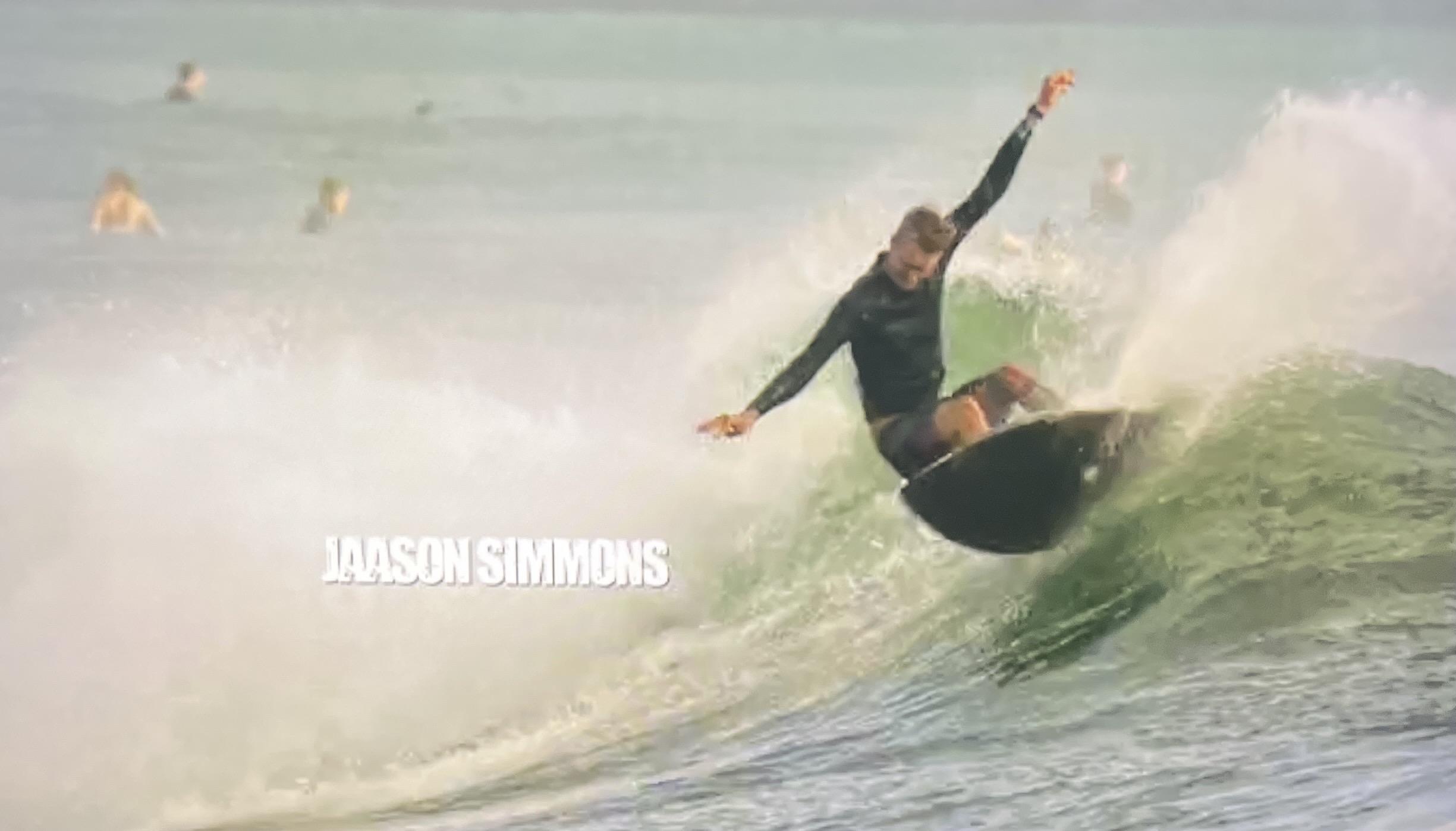 A surfer is surfing a wave. An actors name is in big letters. “Jason Simmons” but Jason is unusually spelled. It is J A A S O N