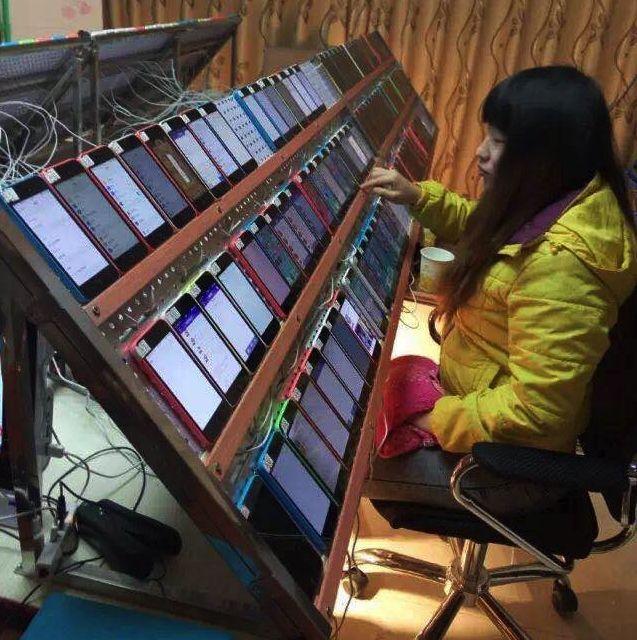 One person managing several dozen mobile phones that are on and talking