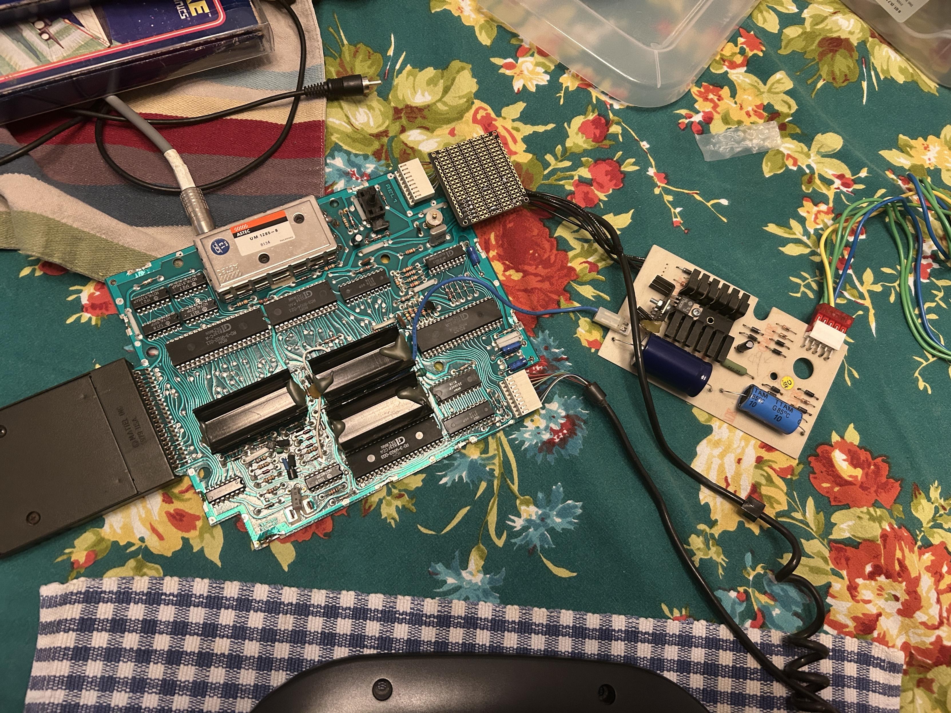 The interdiction main board and power supply sitting on a table top behind a monitor.