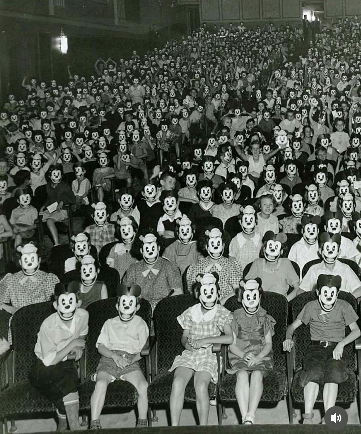 Creepy Mickey mouse club kids in theater all with mickey mouse masks 1930s