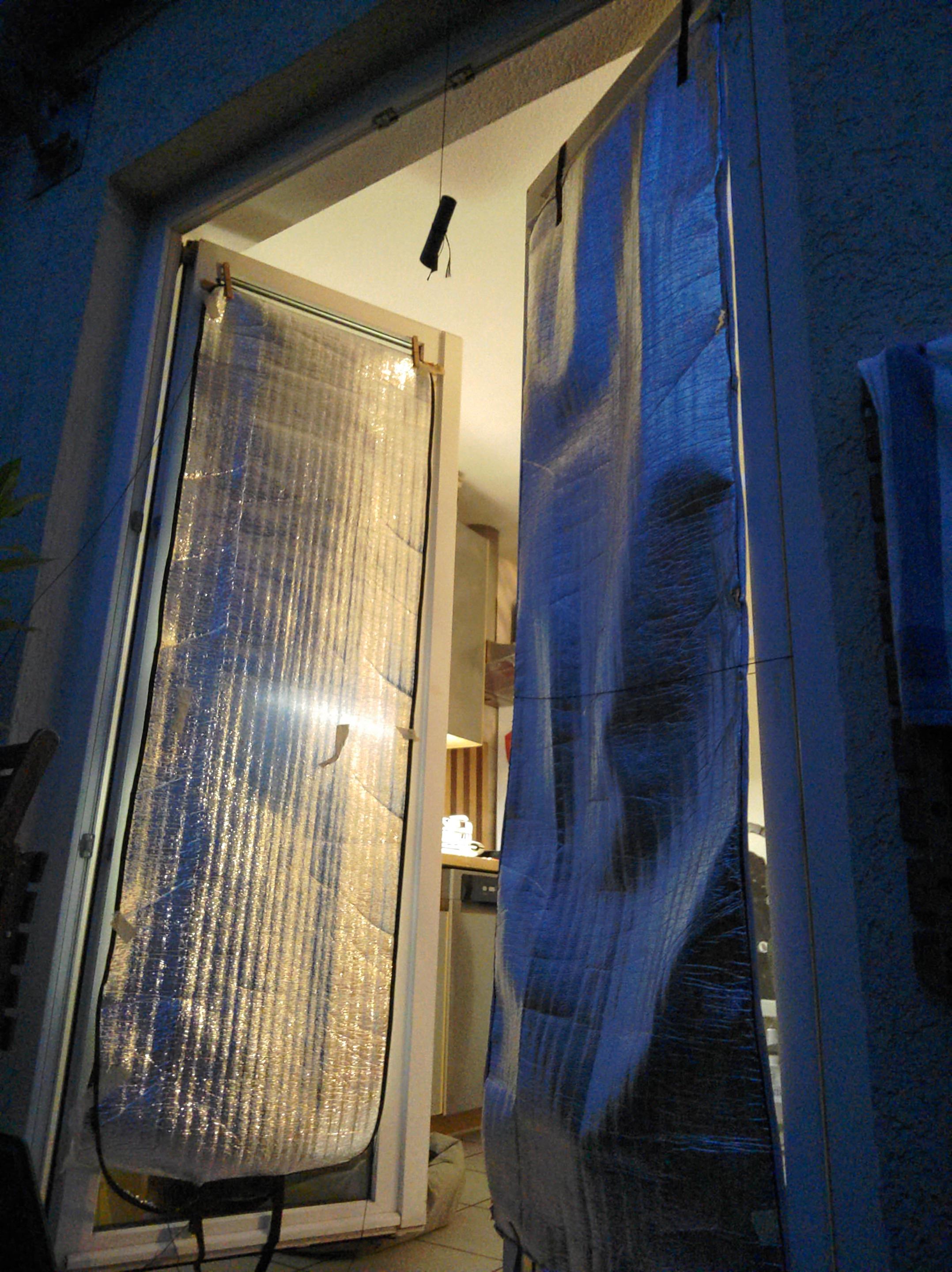Open balcony doors with Mylar mats in front of the glass, attached to the window frames