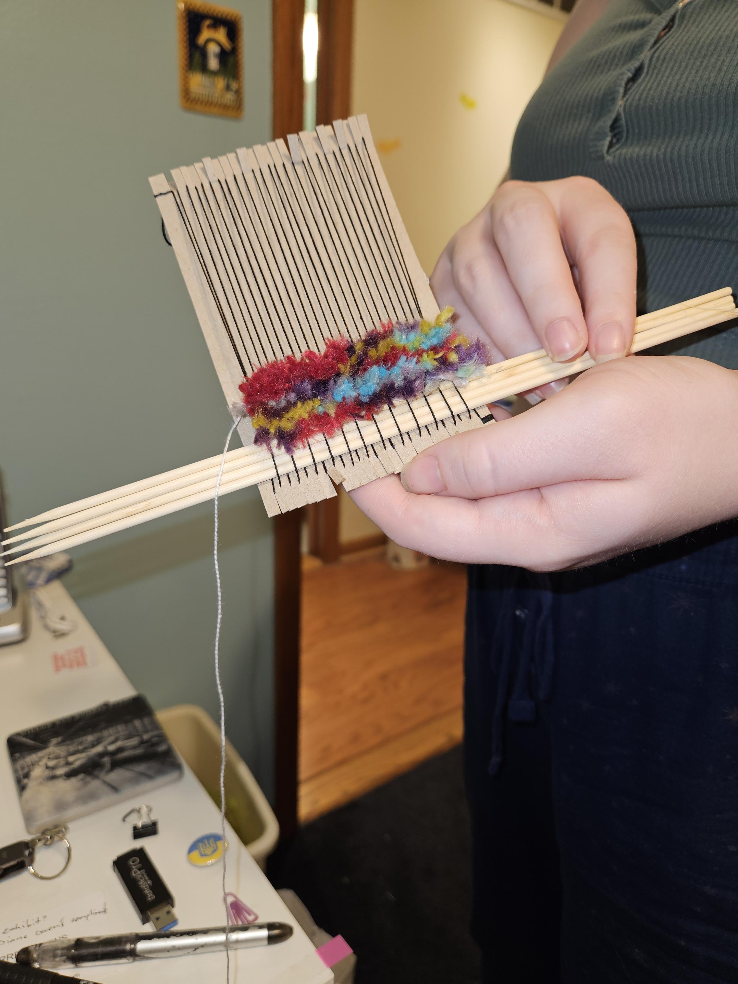 Top side of a hand-made mini-loom.  There are four rows of 80%wool, 20% silk fibers forming a mini rug