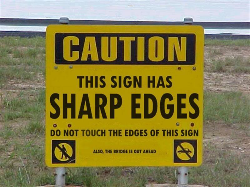 pic of a street sign which says “caution this sign has sharp edges do not touch the edges of this sign also the bridge is out ahead”