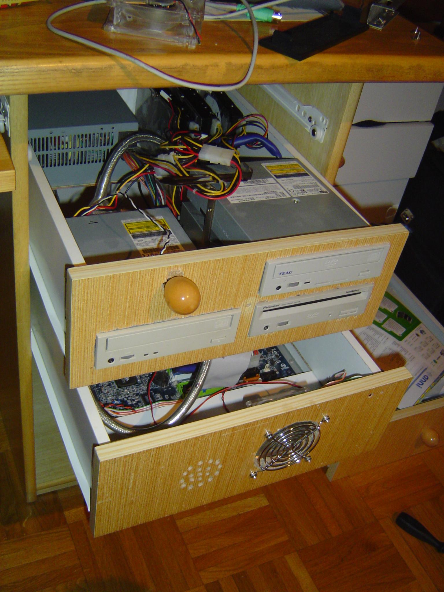 View of both drawers open, the power supply, 3 optical drives and 3 hard drives (mounted vertically) visible in the top drawer, and cables connecting everything to the bottom drawer and power supply.