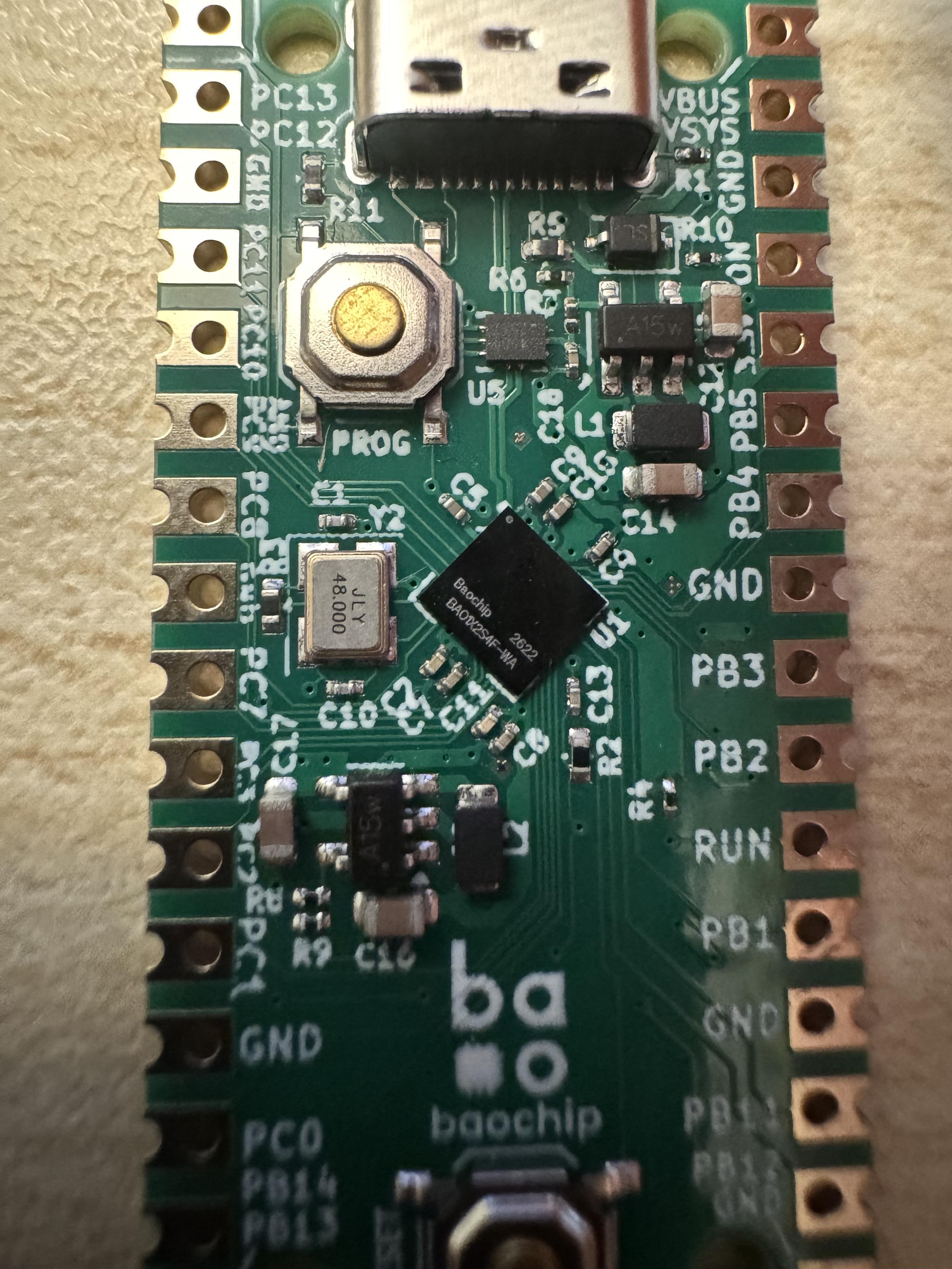 Macro shot showing "Baochip BAO1X2S4F-WA" silicon on a dabao board