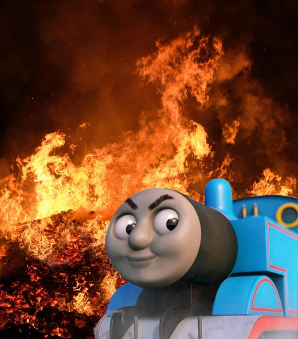 Thomas the Train, smiling with angry eyes while he sits in front of a fire.
